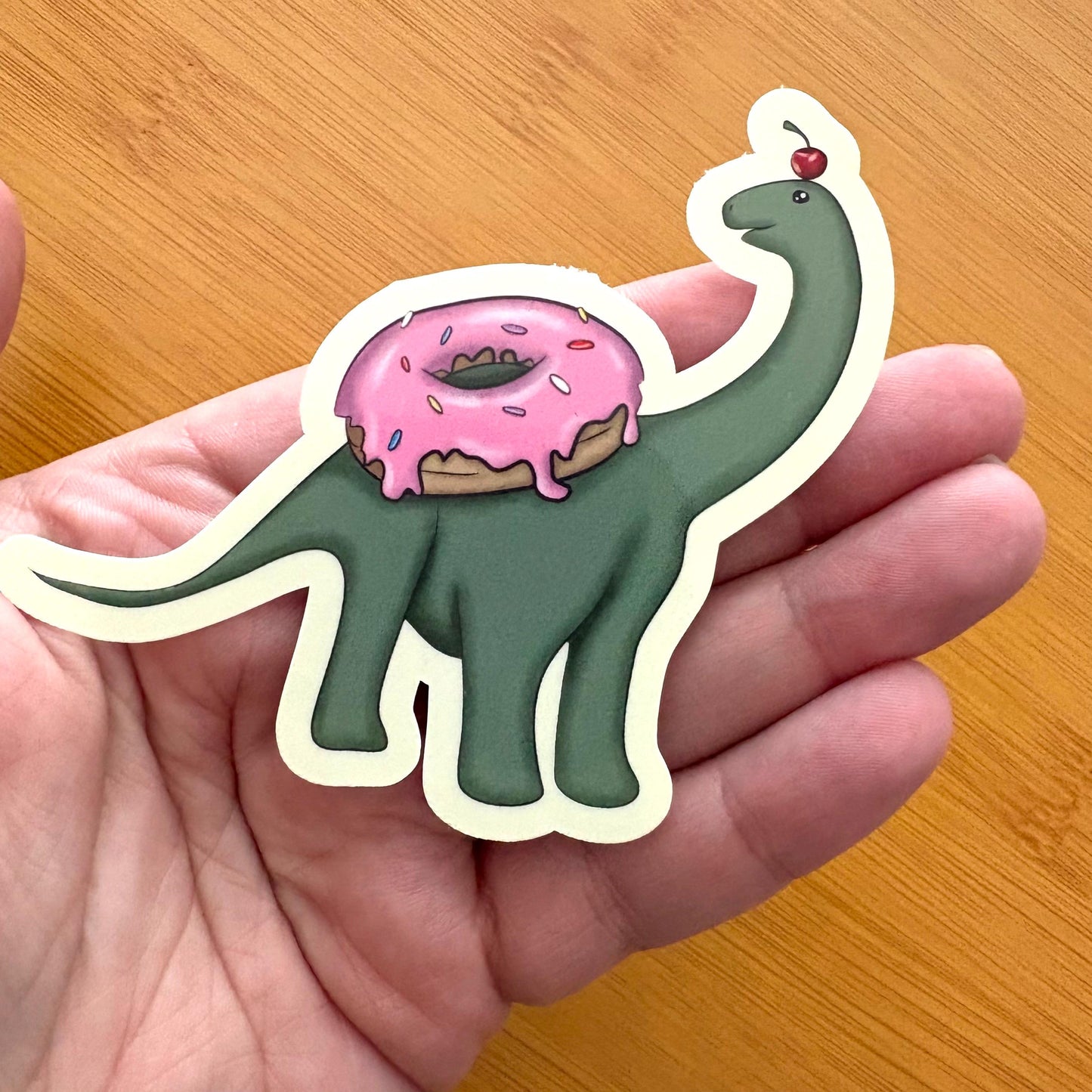 baby brachiosaurus with a donut 3” glossy vinyl laptop water bottle sticker decal