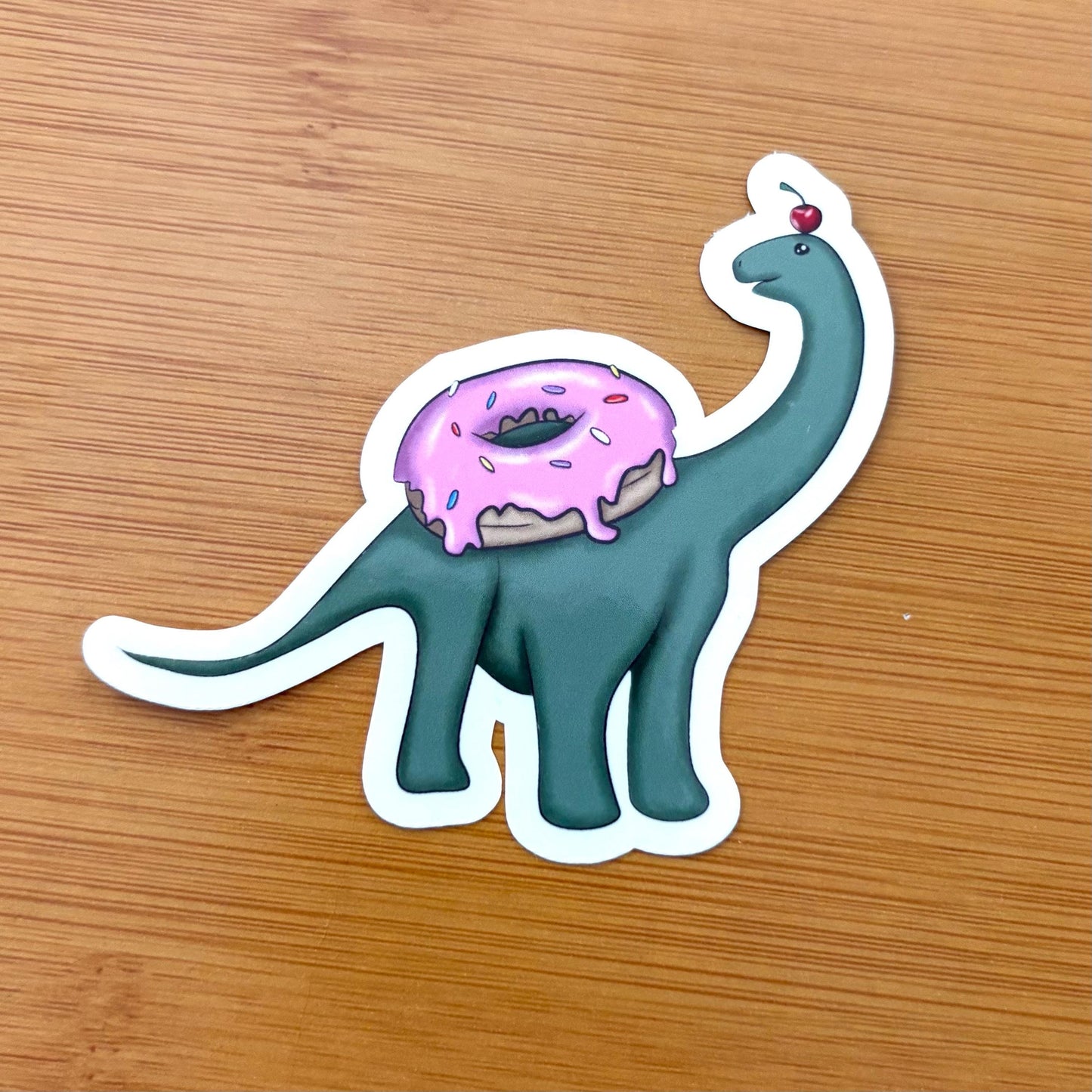 baby brachiosaurus with a donut 3” glossy vinyl laptop water bottle sticker decal